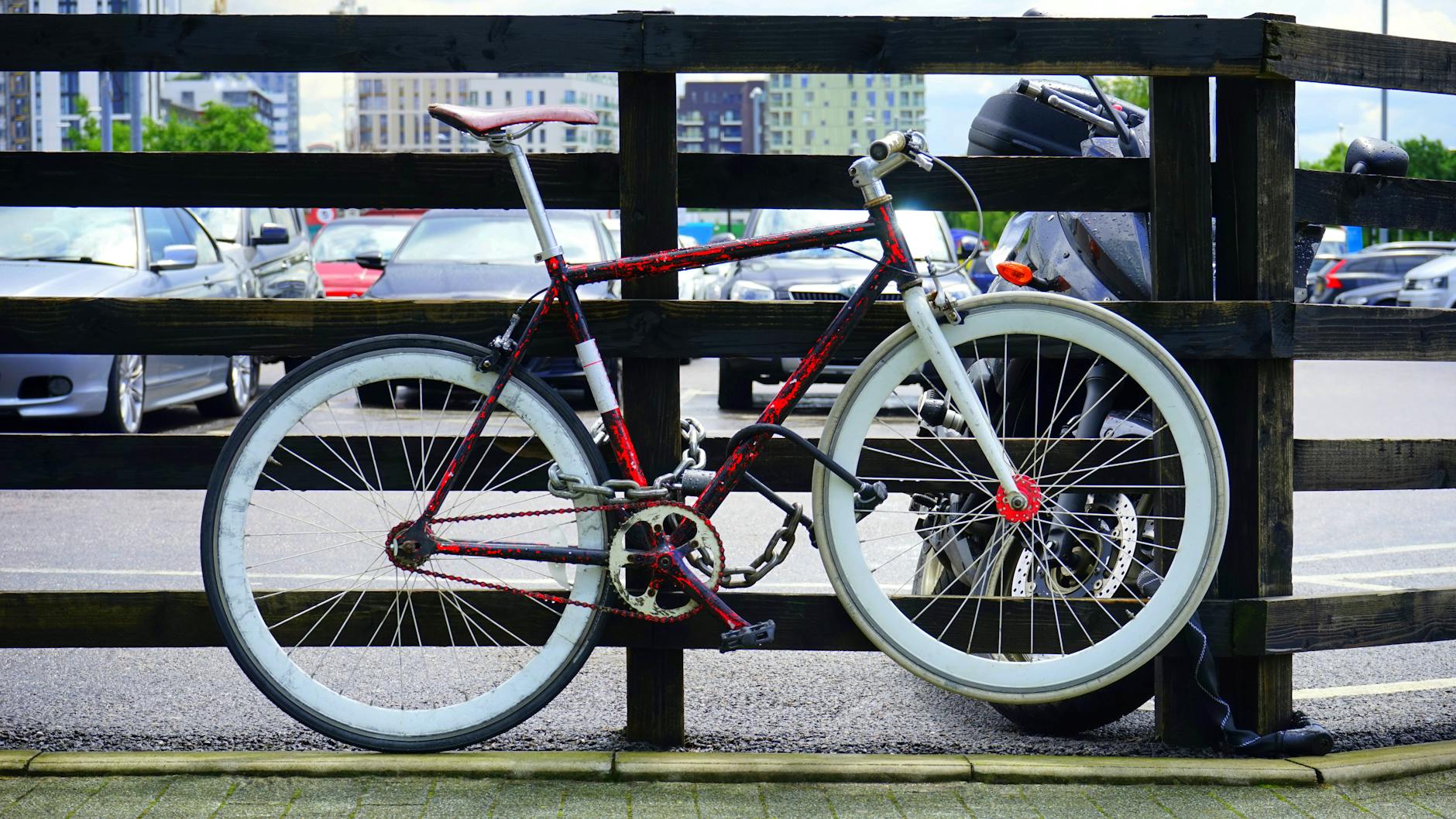 Bike locked to a metal railing outside a Navigli bar at dusk, with people having aperitivo at outdoor tables