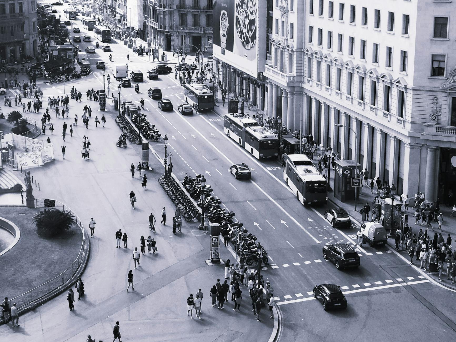 Wide shot of Via Montenapoleone during Fashion Week — pedestrians, photographers crouched