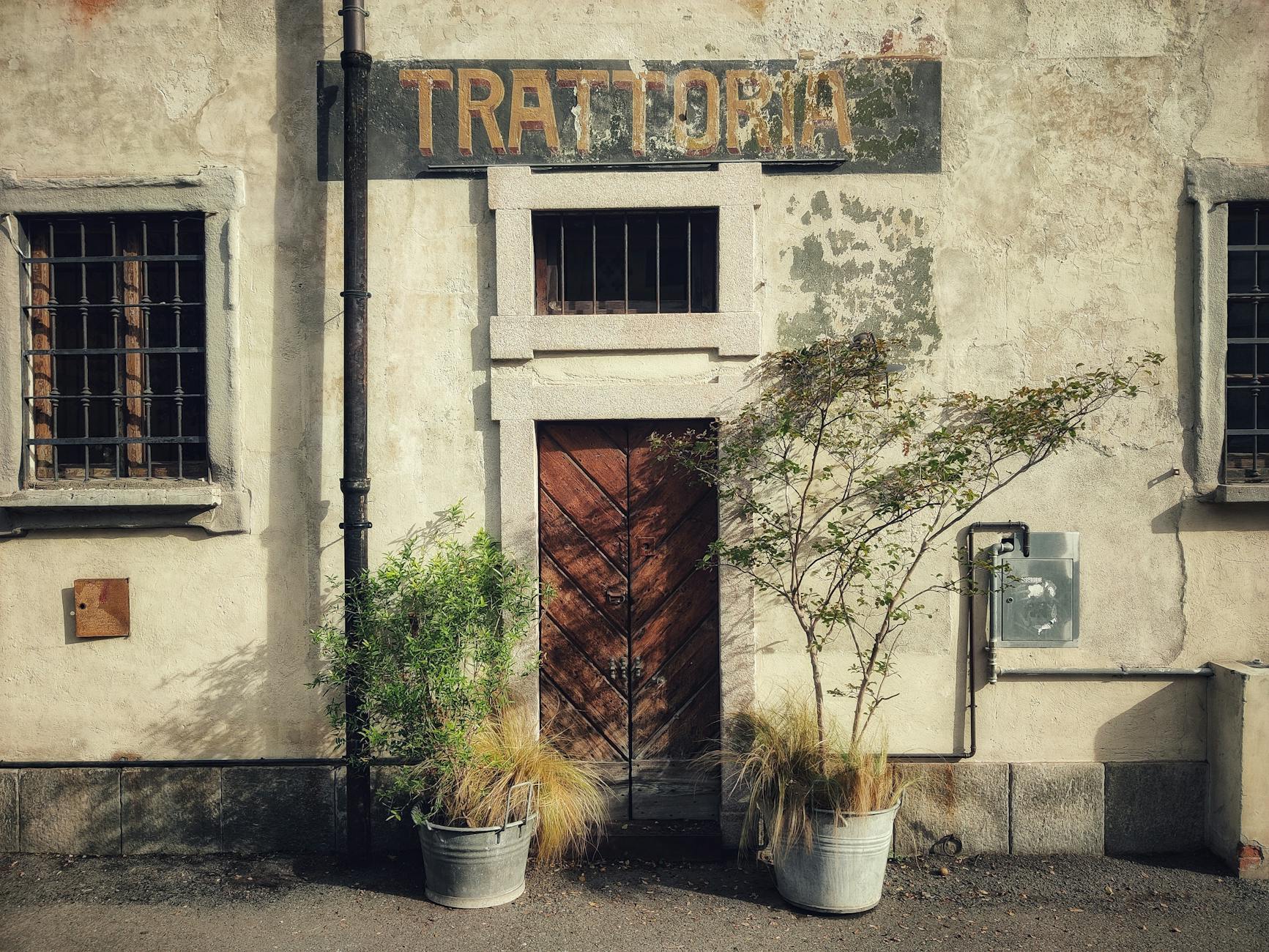 A trattoria interior in Brera in October, dim warm light, a plate of risotto alla milanese with a generous shaving of wh