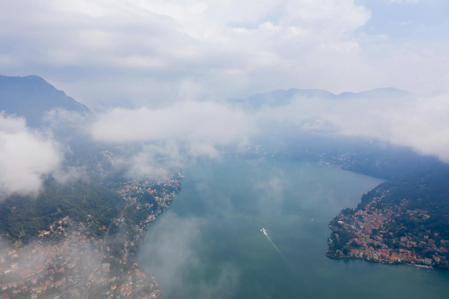 Aerial view of Lake Como with Bellagio peninsula in foreground, Bergamo Alps in distance, golden hour light