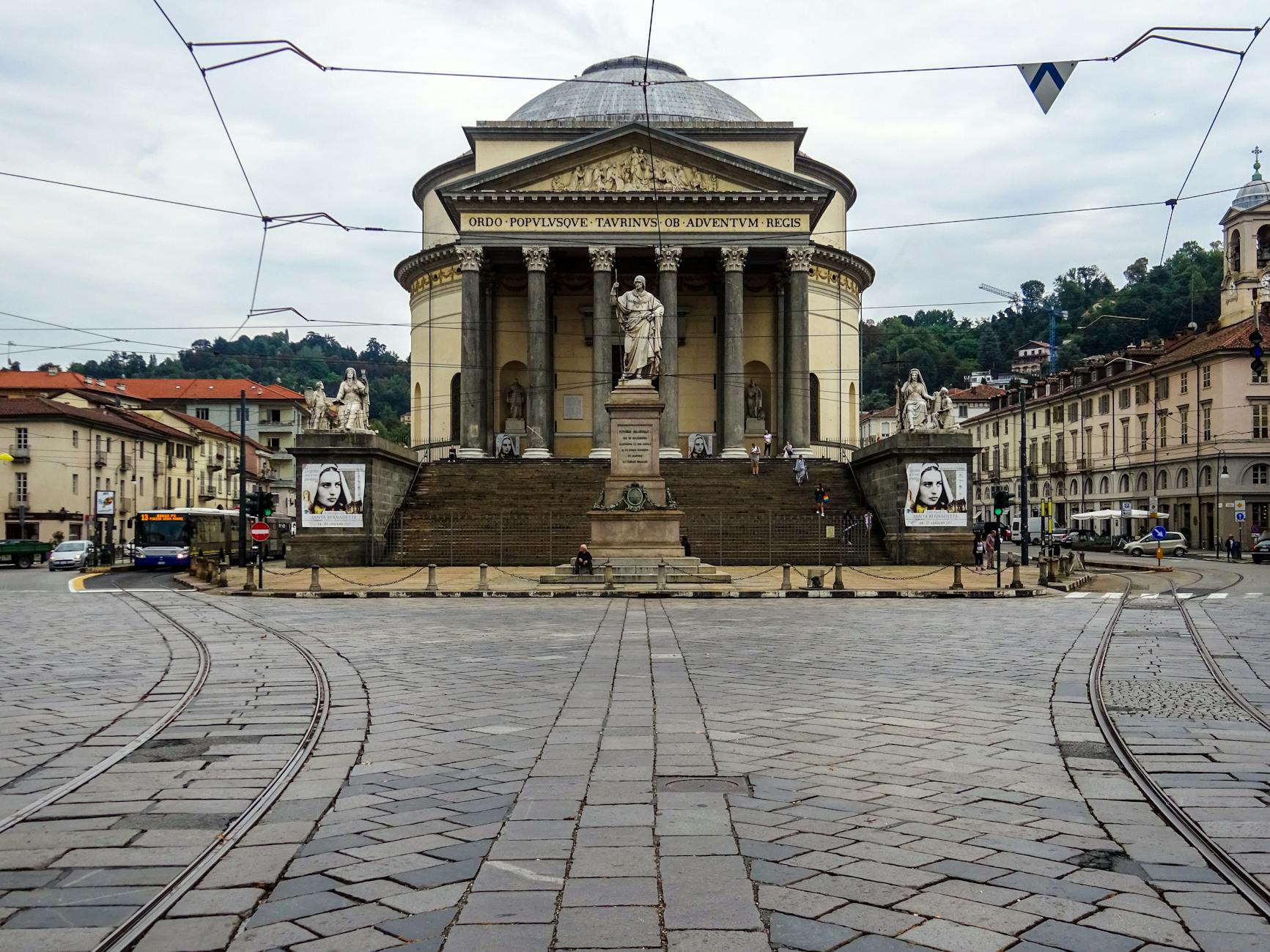 Modern Sirio tram crossing Piazza Cordusio with Duomo spires visible in background