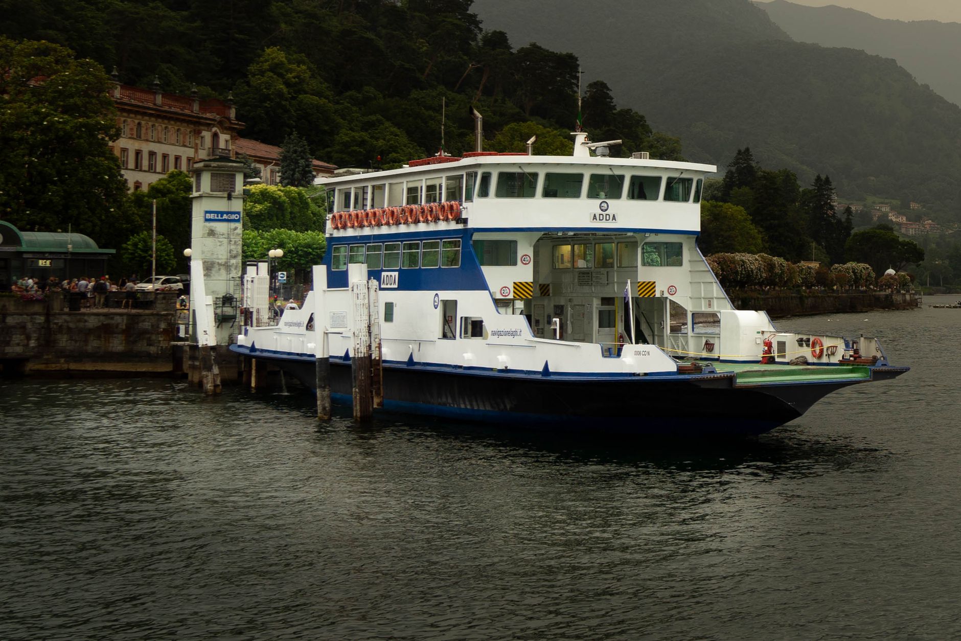 ferry approaching Bellagio harbor on Lake Como with pastel buildings