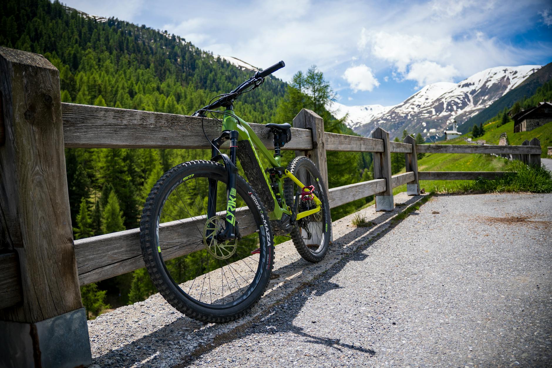Mountain bike resting against a wooden fence in nature