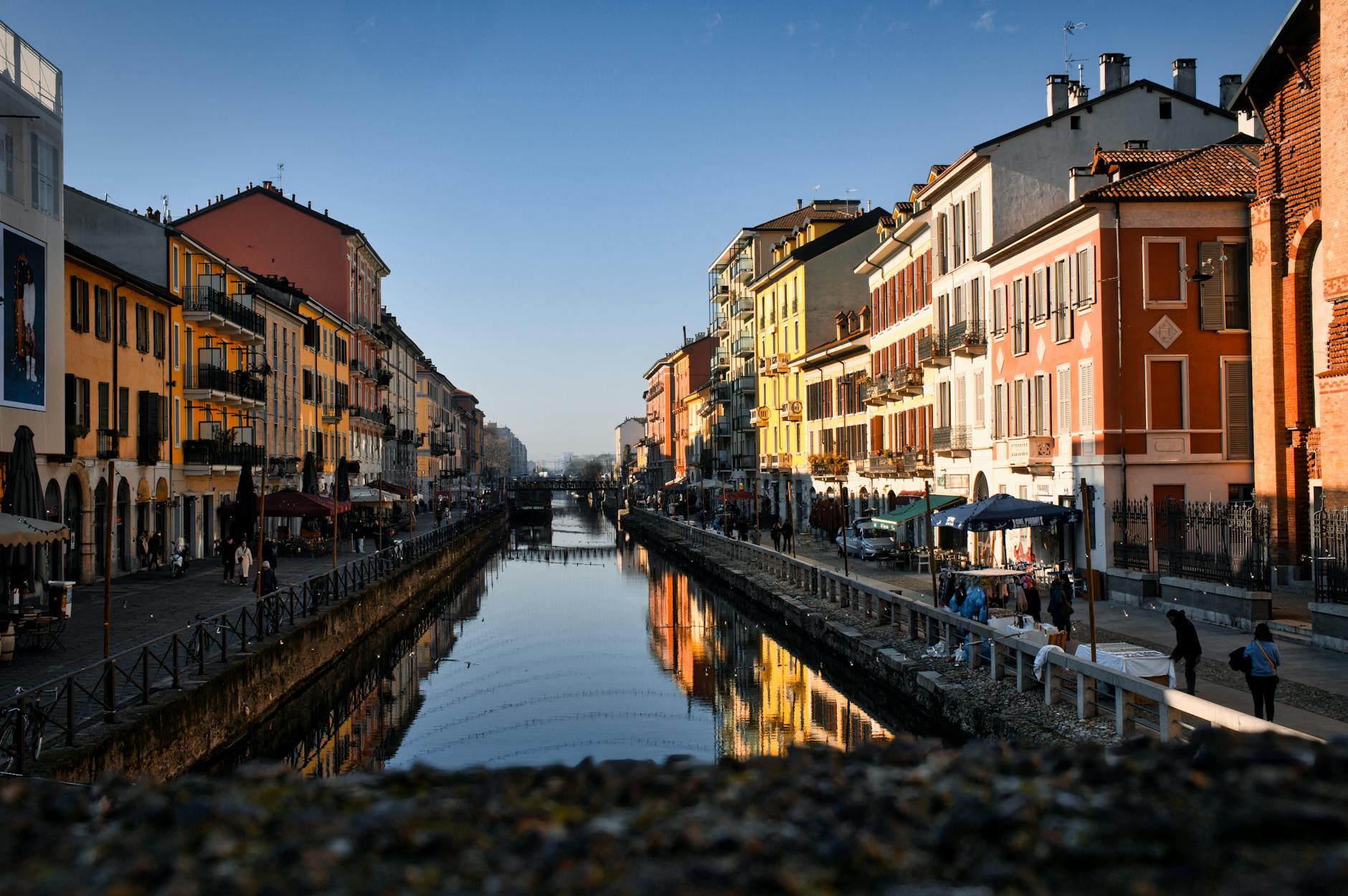 Charming scene of outdoor cafes and colorful buildings lining Milan canals