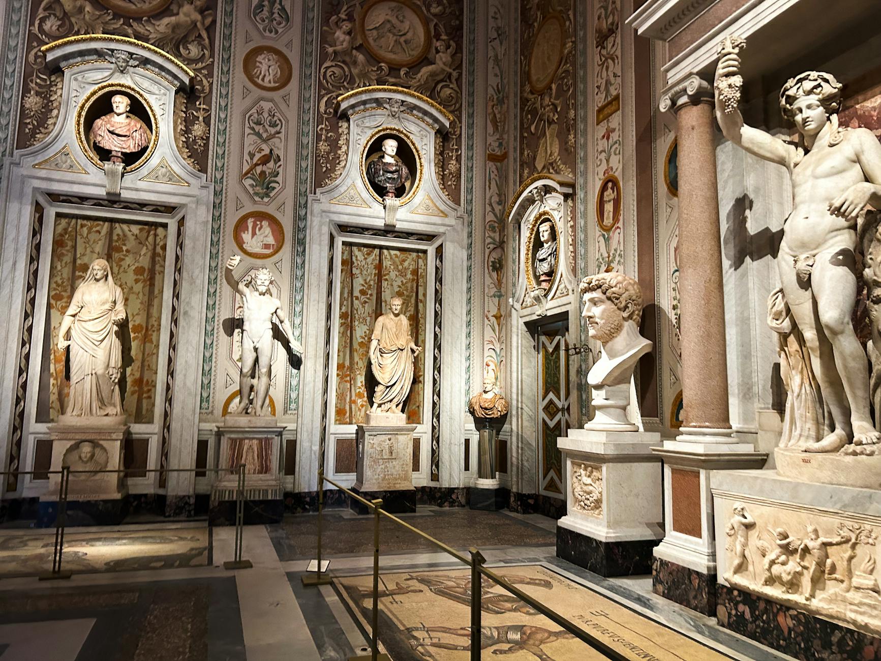 Interior of an Italian museum with classical sculptures and ornate decoration