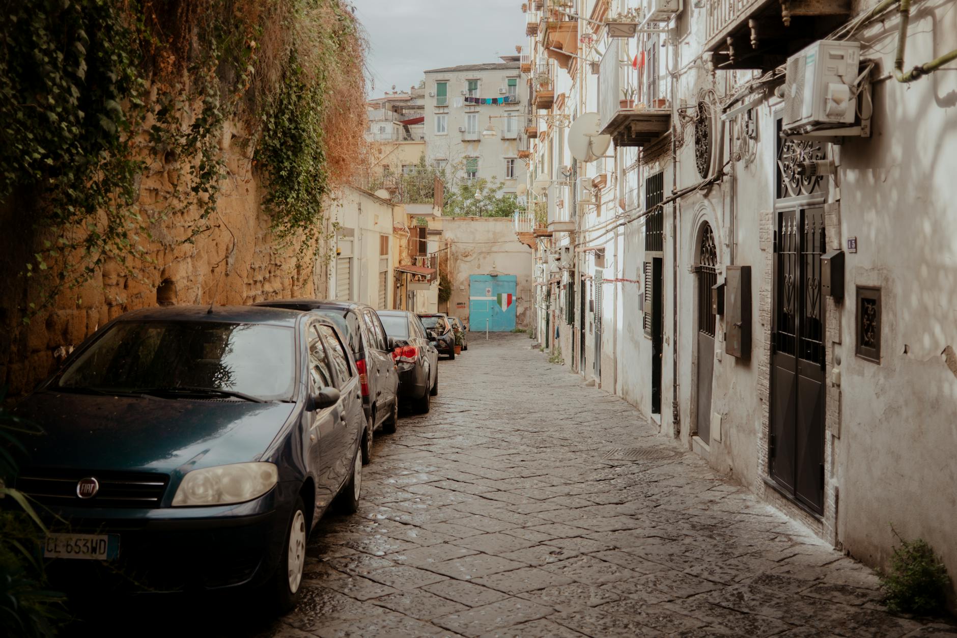 Picturesque narrow alley in Italy with rustic charm and parked cars