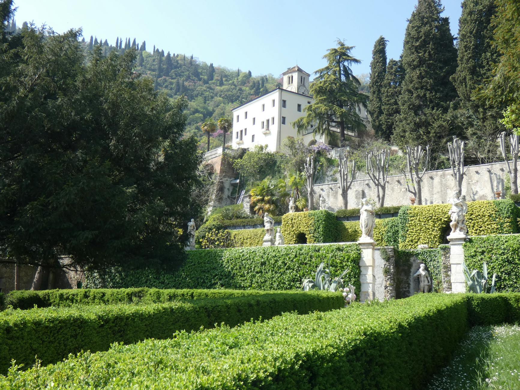Lush hidden Italian garden with classical statues and greenery